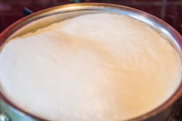 saucepan with boiling milk, foam, hot.