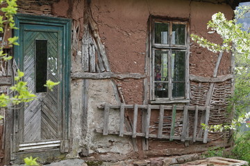 Fototapeta na wymiar Old ruined house adobe and wood facade in village Gara Bov, Bulgaria. Old adobe wall. Brown, detail.