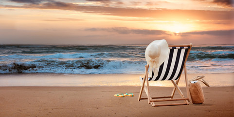 Beach chair with hat on tropic beach