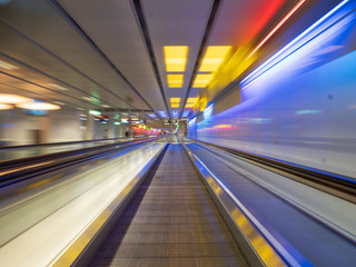 Fototapeta premium Long Exposure moving walkway with neon light at underground