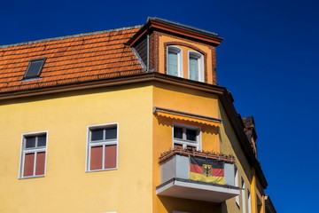Sanierter Altbau mit Deutschlandfahne am Balkon in Berlin, Deutschland