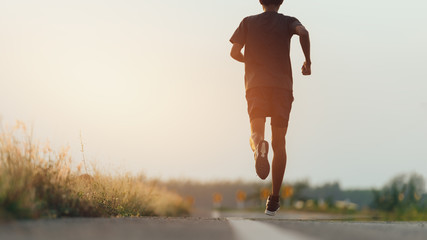 Athlete runner feet running on road, Jogging concept at outdoors. Man running for exercise.