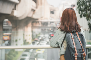 Obraz premium Rear of Woman Traveler with backpack traveling on her summer vacation. Summer Holiday Travel Destination concept.