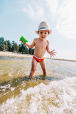 Low angle view of toddler boy playing in the ocean