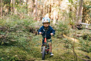 Boy riding bicycle in forest