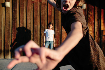 Girl interrupting picture being taken of her sister