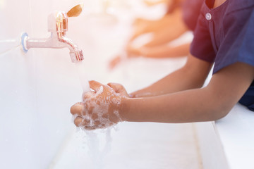 close up hands of children or Pupils At preschool Washing hands with soap under the faucet with...