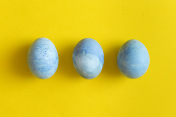 Blue Easter egg on yellow pastel background. Happy Easter concept Organic coloring hibiskus © troyanphoto