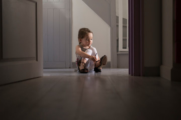 Girl trying on mother's shoe at home