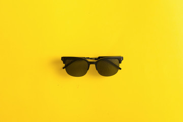 Sunglasses black on yellow background, summer uv protection concept for eyes