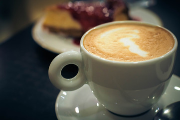 Cup of coffee with milk with delicious cake