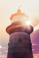 The impressive grainy stone granite of Ramsgate lighthouse, in Thanet, Kent, UK as the late afternoon sunlight shines through the glass of the lamp. The inscription reads "refuge for the unfortunate"