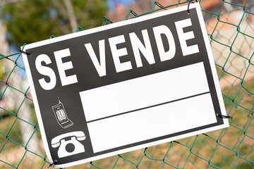 Cartel de "Se Vende" colocado en alambrada protectora de un solar