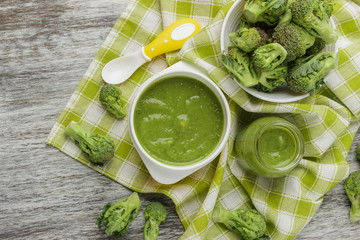 Fresh broccoli in the bowl, and portion of puree made from crushed, boiled broccoli