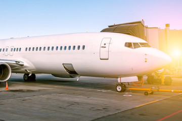 White passenger aircraft parked to a jetway