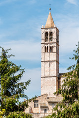 Fototapeta na wymiar Assisi, Italy town or village city in Umbria with Basilica di Santa Chiara Saint Clare church bell towen during sunny summer day vertical view