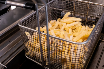 French fries prepared in hot oil in special metal grill