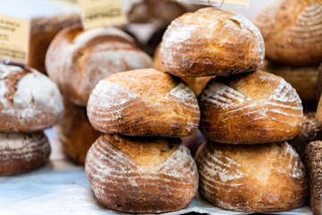 Closeup of fresh traditional baked Italian sourdough bread loaves in bakery with signs