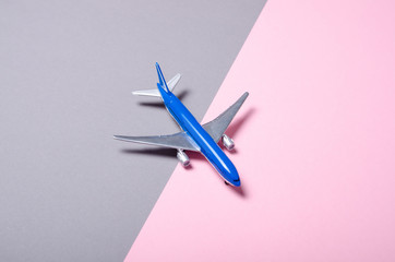 Model airplane on gray pink background, top view