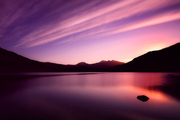 The lake Llynnau Mymbyr reflecting the sky, clouds and sunset with Mount Snowdon in the background. Snowdonia (Eryri), Wales (Cymru), UK.