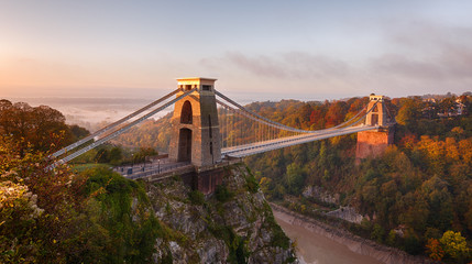 Clifton Suspension Bridge on an autumn morning as the sun rises and breaks through the clouds - obrazy, fototapety, plakaty