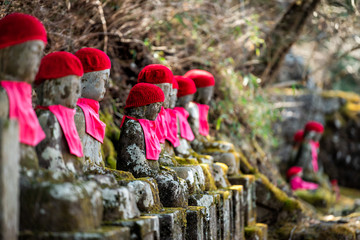 Famous red Jizo statues in Kanmangafuchi Abyss, Nikko, Tochigi in Japan with hats, many figures protecting the dead