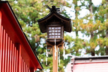 Higashiyama Hakusan Shrine in historical city Takayama, Gifu Prefecture in Japan with closeup of old lantern during day by entrance to temple building