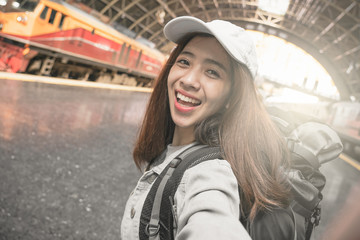 Woman Traveler with backpack traveling taking picture self portrait with smartphone on her summer vacation. Summer Holiday Travel Destination concept.