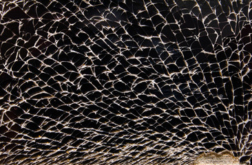 The black surface of broken glass of mobile screen. Cracks and holes on a surface. Сracks, cavities, hollows, cracked smartphone screen. Black mirror concept and symbol. Destructed, broken, shattered.