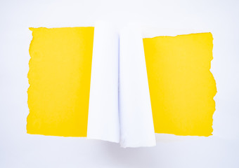 Torn white paper isolated on yellow