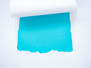 Torn white paper isolated on blue
