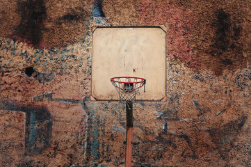 Basketball court outdoor a old brick wall. old basketball hoop