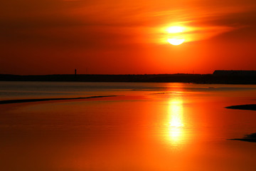 Beautiful orange sunset on the Baltic sea with solar track on the water