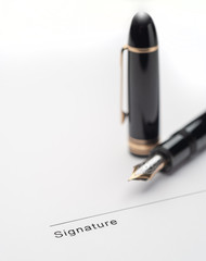 Fototapeta premium Black fountain pen on document pointing to signing area