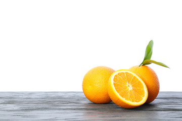 Ripe oranges with leaves on wooden table isolated on white background. Citrus food