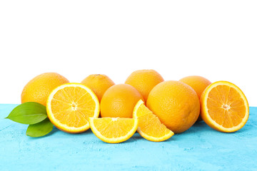 Many oranges with leaves on blue table isolated on white background. Citrus food