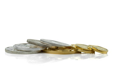 Gold and silver coins in close up isolated on white background with reflection.