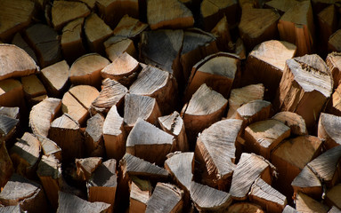 stack of dry chopped firewood logs. Wooden background