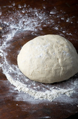 fresh raw dough for pizza or bread baking on wooden table