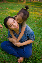 Lifestyle portrait mom and boy in happiness at the outside in the meadow, Funny Asian family in a green park