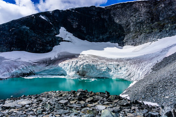 Glacier melting in Norway. Global warming effect on cold environment. Jotunheimen National Park. Glacial lake in front of glacier. - obrazy, fototapety, plakaty