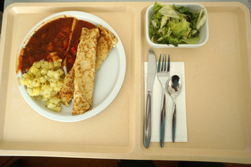 Crepes with potatoes and tomato ragout served on the tray for lunch