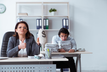Old female boss and young male employee in the office  