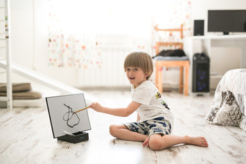 boy draws water and brush on drawing board floor