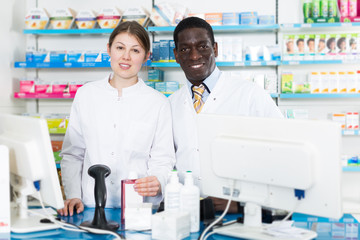 Portrait of man and female pharmacists standing in pharmacy