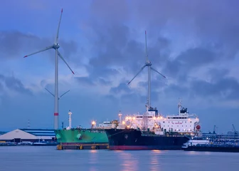 Keuken spatwand met foto Tanker moored at petrochemical production plant with windmills at twilight, Port of Antwerp, Belgium. © tonyv3112