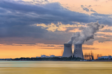 Riverbank with nuclear power plant Doel during a sunset with dramatic cluds, Port of Antwerp, Belgium