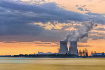 Riverbank with nuclear power plant Doel during a sunset with dramatic cluds, Port of Antwerp,...