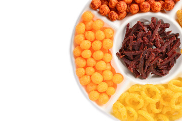 Mix of snacks on a white plate isolated on white.