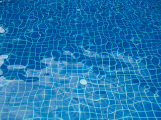 Blue pool water with sun reflections